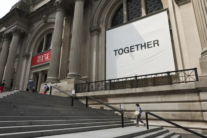 A sign reads TOGETHER on the Met's facade